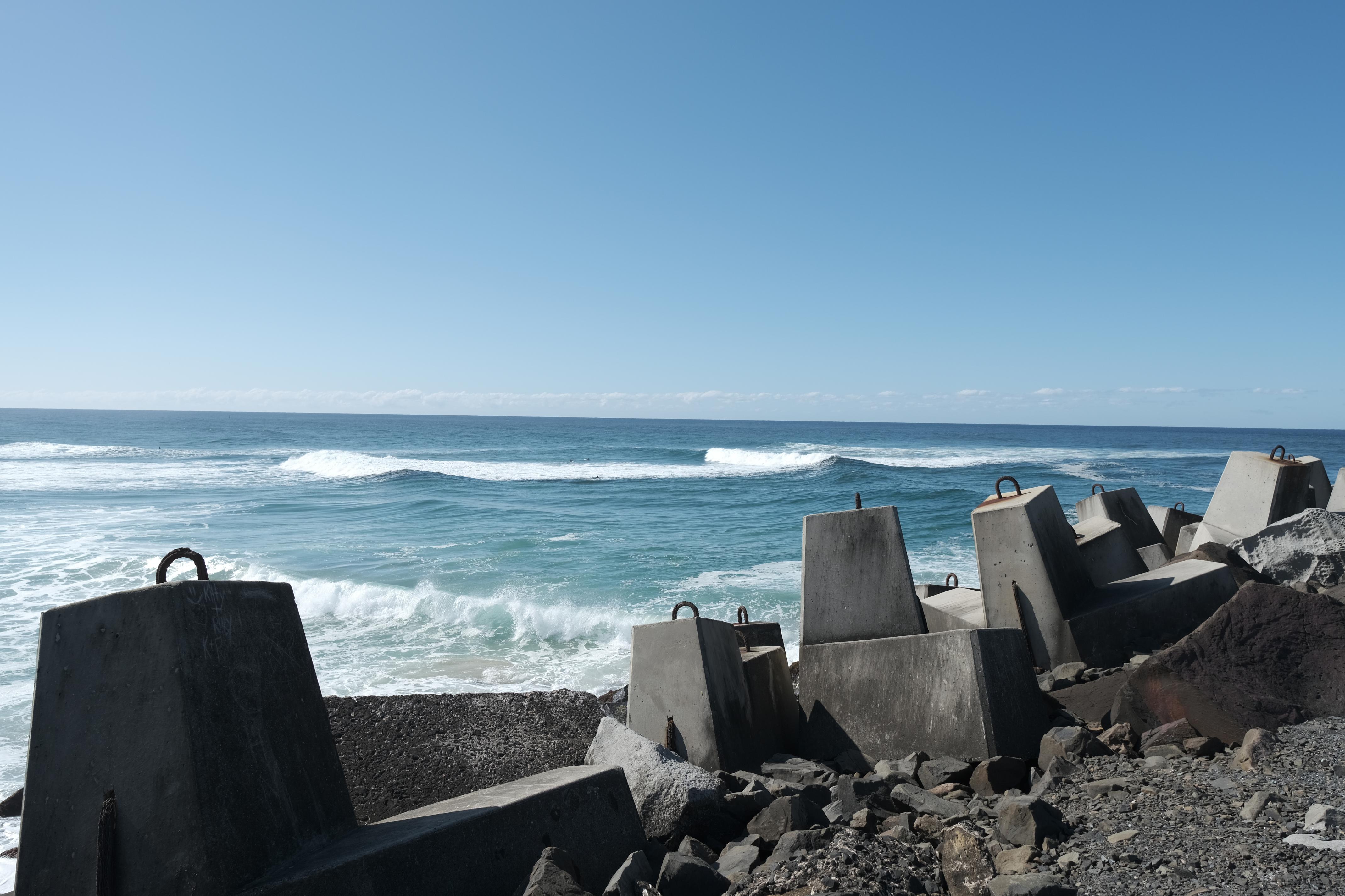 image of ocean with man-made cement pillars in foreground